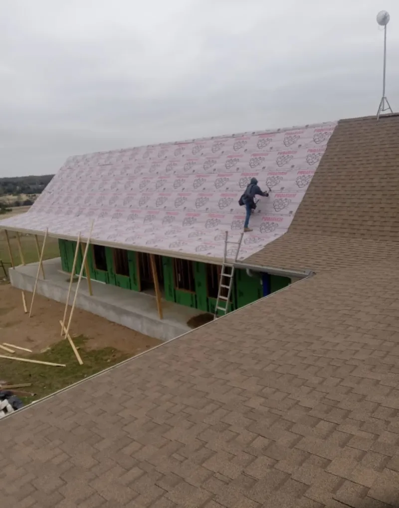 Worker preparing underlayment for a metal roof installation in Gulf Breeze